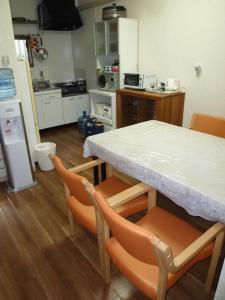 a kitchen with a table and chairs in a room at Rainbow House in Osaka