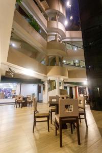 a dining room with tables and chairs in a building at Hotel Janaki in Colombo