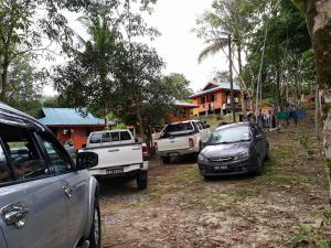 un grupo de autos estacionados frente a una casa en Long Titi Homestay, en Sematan