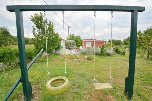 a tire swing with a toilet in a yard at Villa Iva in Kraj