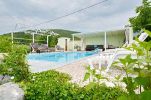 a swimming pool with chairs and a house at Villa Iva in Kraj +41 photos