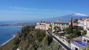 a town on a hill with a mountain in the background at Charming Place 2 Taormina in Taormina