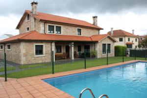 a house with a swimming pool in front of a house at A Lúa do Camiño in Melide