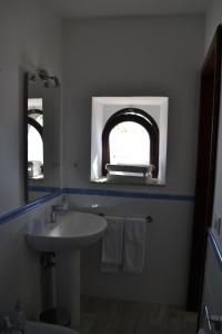 タオルミーナにあるCharming Place 2 Taorminaのバスルーム(シンク、アーチ型の窓付)