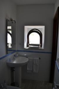 a bathroom with a sink and an arched window at Charming Place 2 Taormina in Taormina