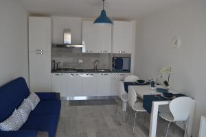 a kitchen and living room with a blue couch and a table at Charming Place 2 Taormina in Taormina