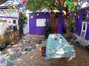 a table in the courtyard of a purple house at Hostel Margo House in Natal