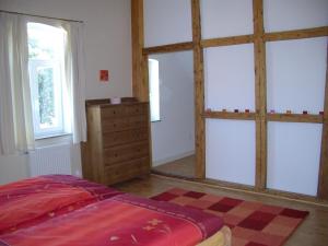 a bedroom with two windows and a bed and a dresser at Zur Windrose Ferienwohnung an der Windmühle Labbus in Sulingen