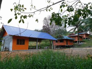 an orange house with a blue roof at Long Titi Homestay in Sematan