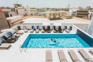 
a swimming pool with a pool table and chairs at Frangiorgio Hotel in Larnaca
