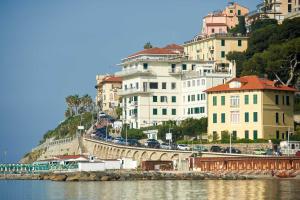 a group of buildings on a hill next to the water at Hotel Corallo in Imperia