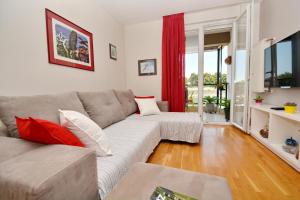 a living room with a gray couch and red curtains at Spacious Premium Apt Lipotica with Oldtown view - Have a memorable holiday in Zadar