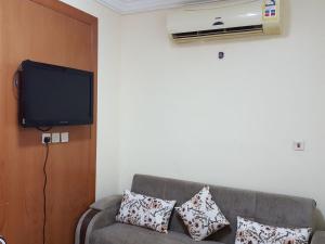 a living room with a couch and a flat screen tv at Al Majdah Hotel in Medina