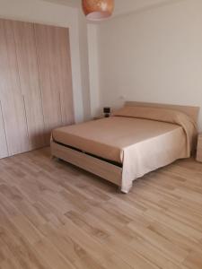 1 dormitorio con 1 cama y suelo de madera en Merlino house en Tropea