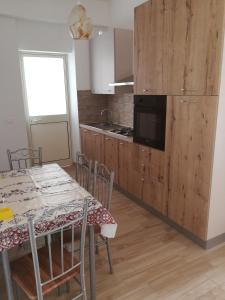 cocina con mesa con sillas y mesa y cocina con nevera en Merlino house en Tropea