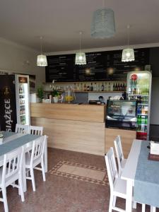 a restaurant with white tables and chairs and a counter at Elexia in Sianozety