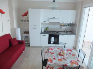 ein Wohnzimmer mit einem Tisch und einer roten Couch in der Unterkunft Appartamento Belvedere 4 in Stresa + 21 Fotos