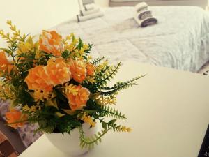 a white vase with orange flowers on a table at Il Rifugio Sui Due Golfi in Casola di Napoli