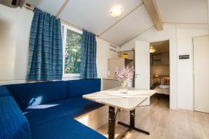 Manjadvorci的住宿－Mobile Homes Dvor，客厅配有蓝色的沙发和桌子