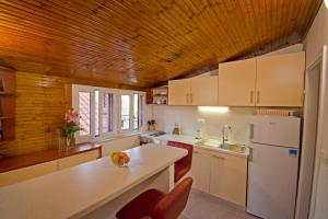 a kitchen with white appliances and a wooden ceiling at 3M Peristil in Split