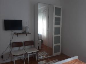 a living room with two chairs and a mirror at Apartments Pag Holiday in Pag