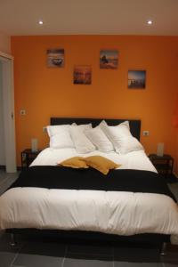HazelbourgにあるLa Croix Du Loupのオレンジ色の壁の客室で、大型ベッド1台が備わります。