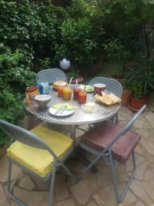 ニースにあるVilla Chamadeのテーブルと椅子、食べ物と飲み物