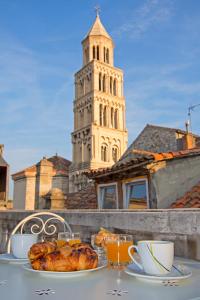a table with a plate of food and a tower at 3M Peristil in Split