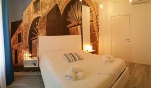 a bedroom with a white bed with towels on it at Lyria in Marzamemi