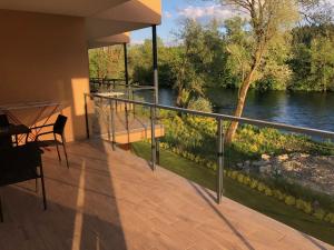 a balcony of a house with a view of a river at Apartmánový Dom Kriváň in Bešeňová