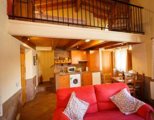 a living room with a red couch and a loft at El Bulín de Piñuecar in Piñuécar