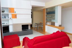 a living room with a red couch and a fireplace at Il Campanile in Vico Equense