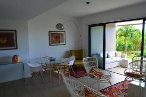a living room with a table and chairs at AZURI Serviced Garden Apartment in Roches Noires