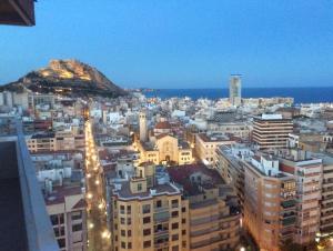 eine Stadt in der Nacht mit einem Berg im Hintergrund in der Unterkunft Apartamento & sea view in Alicante