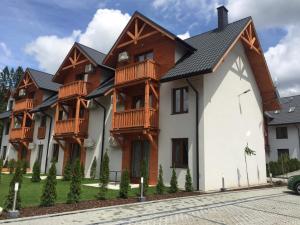 a house with wooden balconies on it at Szczawnica Apartament Kaja in Szczawnica