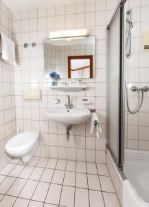 
a bathroom with a sink, toilet and mirror at Hotel Zeller Zehnt in Esslingen
