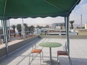 una mesa verde y 2 sillas en el techo en Nino´s Residence Departamentos VIP Amoblados, en Tacna