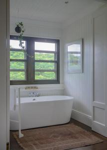 uma banheira branca na casa de banho com uma janela em Torburnlea Homestead Luxury Accommodation em Nelspruit