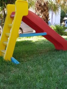 a set of childrens play equipment in the grass at La casa del melograno in Marsala