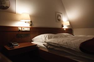 a hotel room with a bed and a phone on a table at Hotel Zeller Zehnt in Esslingen