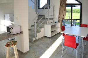 a kitchen and dining room with a staircase and red chairs at Rio y Piedras in Colón