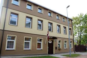 een huis met een vlag ervoor bij Windrose in Liepāja