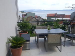 a table and chairs on a balcony with a view of the ocean at Apartments Pero in Podgora