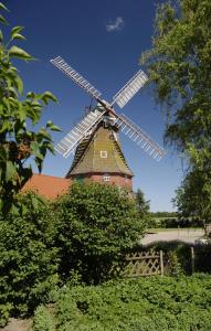 un moulin à vent installé au-dessus d'un bâtiment dans l'établissement Zur Windrose Ferienwohnung an der Windmühle Labbus, à Sulingen