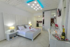 a white bedroom with a bed and a dining table at FTELIA LUXURY STUDIO ''QUATTRO'' in Megali Ammos