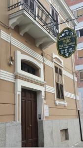 a sign in front of a building with a balcony at B&B Centro Storico 900 in Palmi