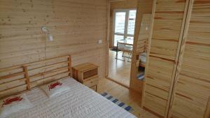 a bedroom with a bed in a wooden room at Pajūrio brizas in Šventoji