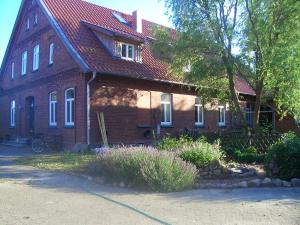 une maison en briques brunes avec un toit rouge dans l'établissement Zur Windrose Ferienwohnung an der Windmühle Labbus, à Sulingen
