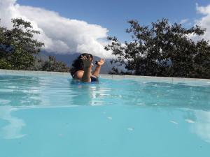 una mujer en el agua en una piscina en Hotel Esmeralda, en Coroico