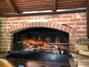 un cerdo está cocinando en un horno de ladrillo en Plitvice Rooms Family Glumac, en Lagos de Plitvice